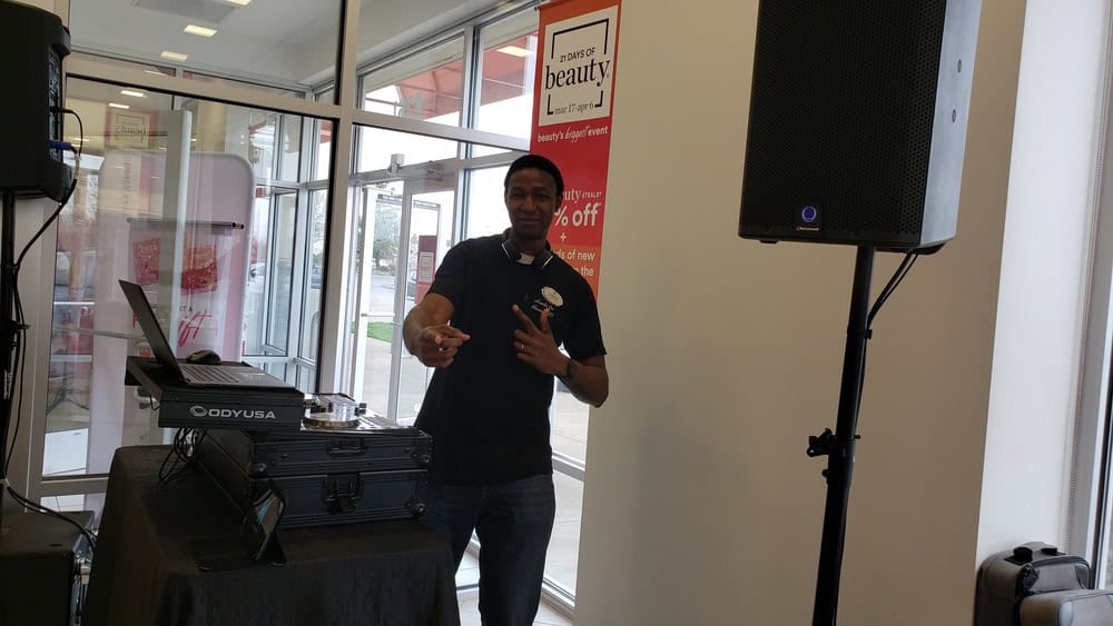A picture of DJ Aaron Harris posing for a picture next to his DJ setup for a Too Faced Cosmetics event in Ulta Beauty.